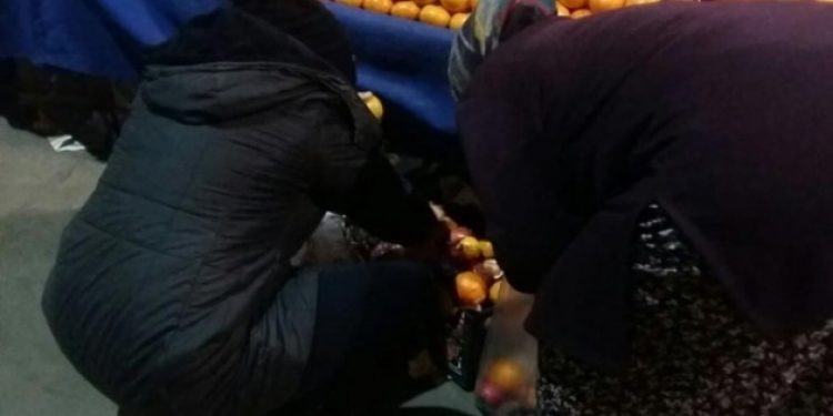 Tezgah altından sebze-meyve toplayan kadınlar